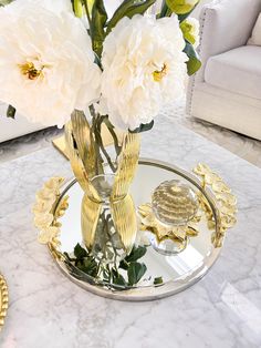 two white flowers in a glass vase on a marble table with gold trimmings