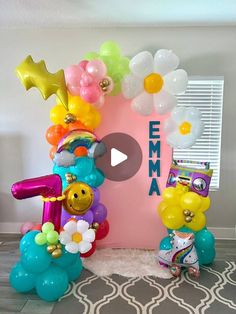 the balloon arch is decorated with flowers and balloons