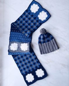 two knitted hats and scarfs on a marble surface