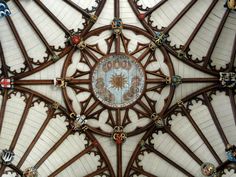 an ornate ceiling in the middle of a building with stained glass and metal decorations on it