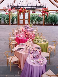 a table set up for an event with pink and green linens