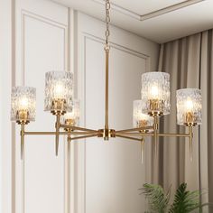 a chandelier with five lights hanging from the ceiling in a living room or dining room