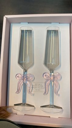 two clear wine glasses with bows in a box