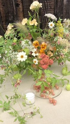 a vase filled with lots of flowers on top of a table