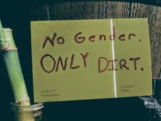 a sign that says no gender only dirt next to a bamboo plant with writing on it