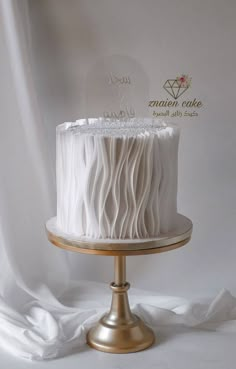 a white cake sitting on top of a gold plate