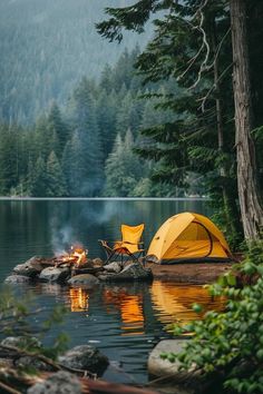 a tent is set up on the shore of a lake