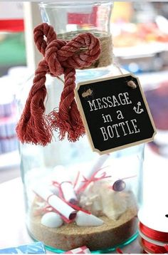 a message in a bottle is displayed on a table with candy and other items around it