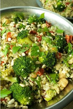 broccoli and other vegetables are mixed together in a silver bowl on a table