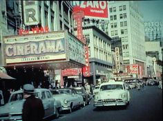 an old photo of cars and people on the street