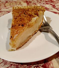 a piece of pie sitting on top of a white plate with a fork in it