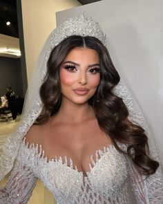 a woman in a wedding dress posing for the camera with her veil over her head