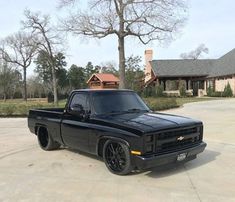 a black truck parked in front of a house