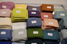 many folded sheets are stacked on top of each other with labels attached to them in rows