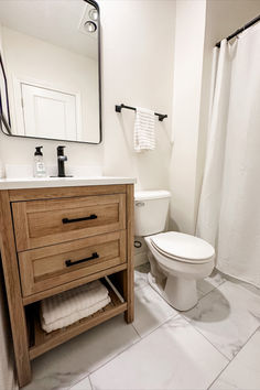 a bathroom with a toilet, sink and mirror