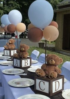 a table topped with plates and balloons filled with teddy bears sitting on top of each other