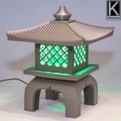 a small lantern with green lights in the shape of a pagoda