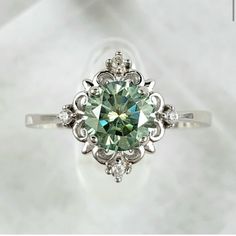 an engagement ring with a green diamond in the center