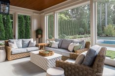 a living room filled with lots of furniture next to a window covered in greenery