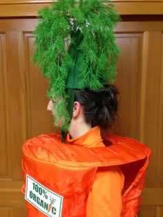 a person wearing an orange costume with green plants on their head