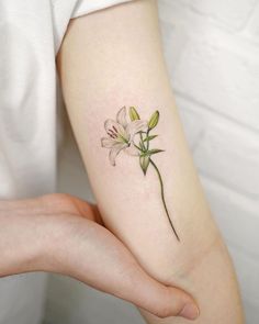 a woman's arm with a flower tattoo on the left side of her arm