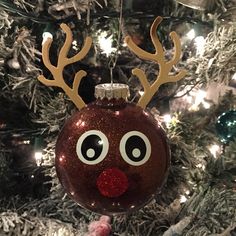 a christmas ornament hanging from a tree with reindeer's nose and antlers on it