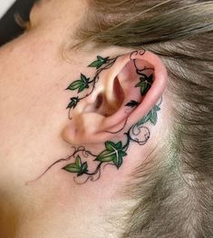 a woman's ear with green leaves on it