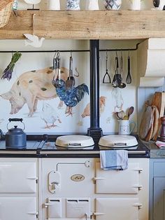 an old fashioned stove with many pots and pans hanging from it's wall