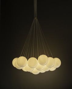 a chandelier hanging from a ceiling in a dark room with five lights on it