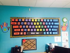 a bulletin board on the wall above a desk with a keyboard and mouse in front of it