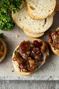 an assortment of breads with meat and vegetables on them sitting on a counter top