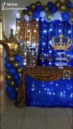 a blue and gold birthday party setup with balloons, streamers, table cloths and decorations