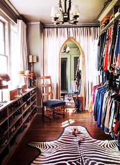 a room filled with lots of clothes and furniture