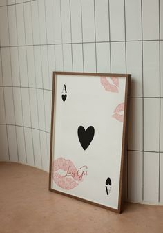 a card with hearts and kisses drawn on it in front of a tiled wall