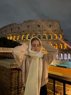 a woman standing in front of the colossion with her hands on her head