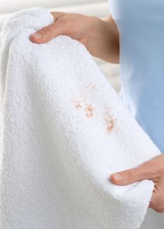 a person holding a white towel with brown spots on it