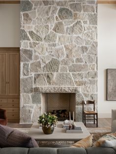 a living room with a large stone fireplace