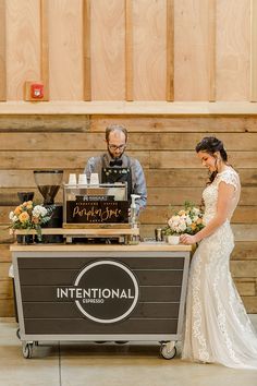 a man and woman standing next to each other in front of a counter