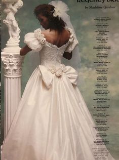 the back of a wedding dress with ruffles and flowers on it, in front of a column