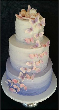 a three tiered cake with white frosting and pink flowers