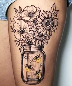 a woman's thigh with sunflowers in a mason jar tattoo on it