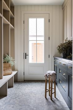 an empty room with two stools in front of the door and shelves on both sides