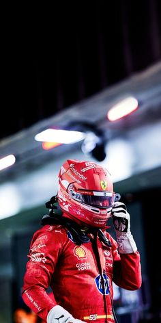 a man in a red suit and helmet talking on a cell phone