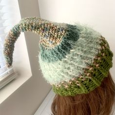 a close up of a person's head wearing a knitted hat