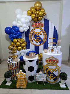 a table with balloons and decorations for a soccer themed birthday party in blue, gold and white