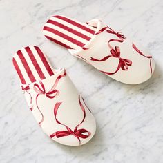 two red and white slippers with bows on them sitting on a marble counter top