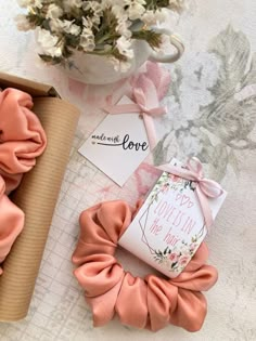 two scrunffle hair ties on top of a table next to a vase with flowers