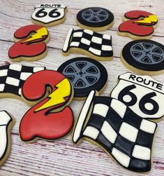 decorated cookies are arranged in the shape of cars and race flags on a wooden table