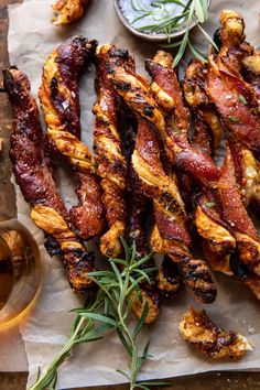 chicken wings with rosemary garnish on parchment paper next to small bowl of sauce