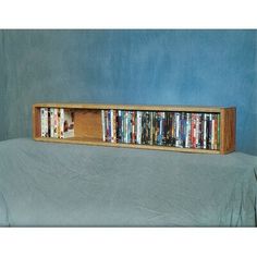 a wooden shelf with several dvd's in it on top of a white sheet